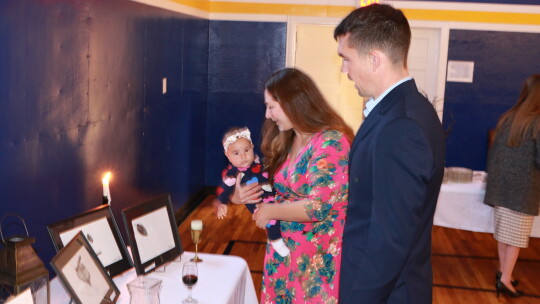 The Stark family looks at student artwork on display during the event. The artwork was available for a donation to the high school expansion fund.