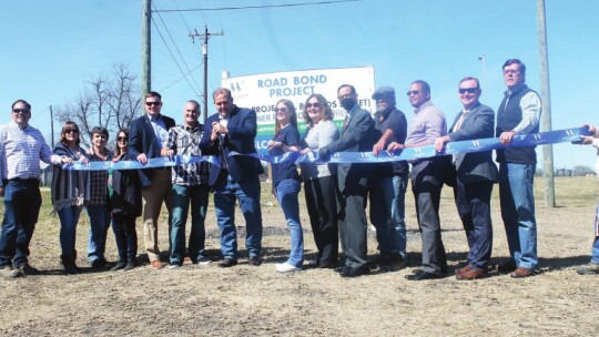 Commissioner Russ Boles cuts the ribbon alongside Mayor Troy Marx (left) on completed improvements to South Bounds Street in Thrall Feb. 28. Photo by Fernando Castro