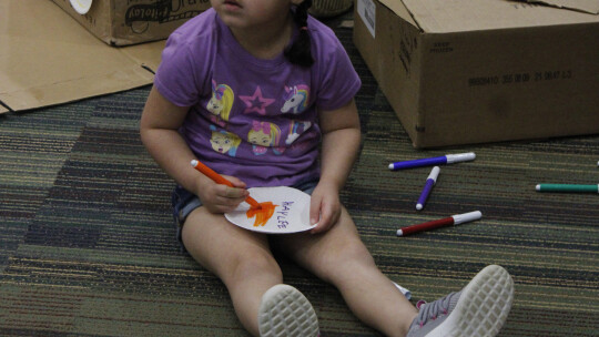 Haylee Synatzske works on her colorful creation during last Tuesday’s cardboard kingdom spring break event. Photos by Matt Hooks