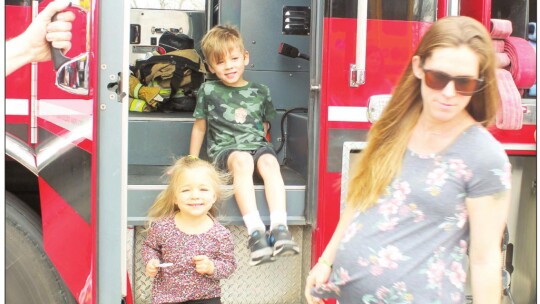 Sophia, 3, and Alex, 5, Loveless exit a fire truck during the Truck Petting Zoo in Taylor March 17.