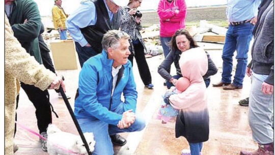 Williamson County Judge Bill Gravell kneels to talk with a young girl, Hunnie, near Granger March 23 about her family’s recent experience with a tornado. Facebook / Judge Bill Gravell