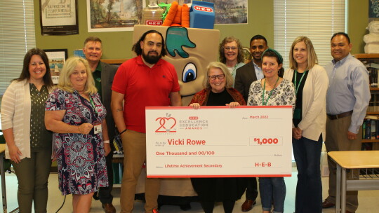 Taylor ISD Superintendent Devin Padavil and school board president Marco Ortiz join Taylor High School staff in congratulating Vicki Rowe on being named a finalist for the HEB Excellence Award. Photo by Tim Crow