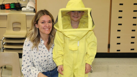  Elijah Sackett learns about beekeeping from Allison Slabotsky. Photo by Tim Crow