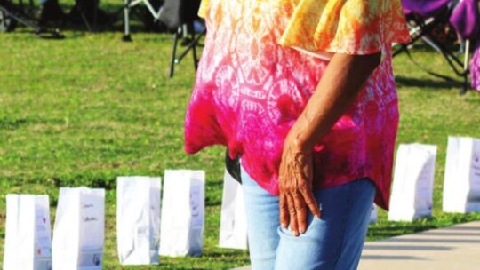 Laverne Caldwell looks at the unique designs and colorful displays on luminaria bags. Photo by Jason Hennington