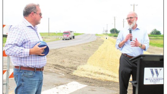 Mayor Brandt Rydell (right) lauds Commissioner Russ Boles during a ribbon cutting ceremony in front of County Road 101 in Taylor May 4. Photos by Fernando Castro