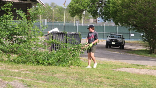 THS senior Jackson Schroeder helps clean-up the yard at American Legion Post 39, Taylor in honor of Columbine Day. Photo by Tim Crow