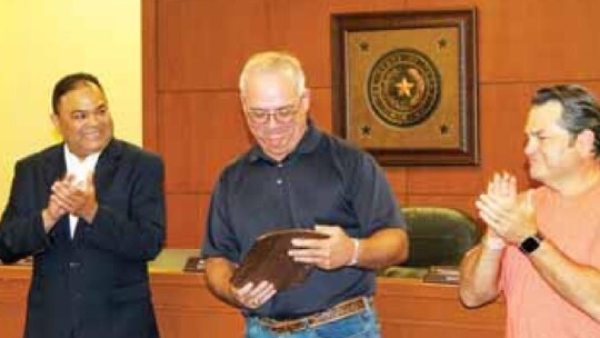 Thomas Rohlack (middle) holds his plaque alongside fellow board members Marco Ortiz (left) and Jim Buzan during their meeting in Taylor May 16. Photos by Fernando Castro