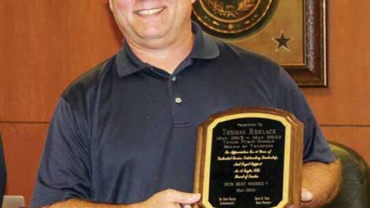 Thomas Rohlack holds his plaque commemorating his service to the Taylor ISD board of trustees during their meeting in Taylor May 16. Photos by Fernando Castro