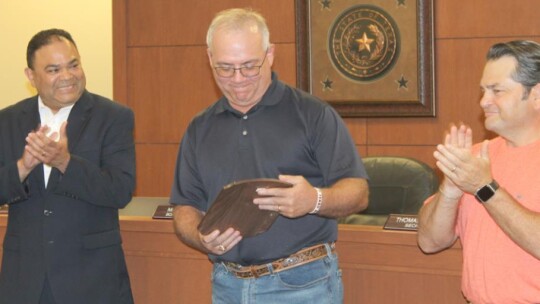 Thomas Rohlack (middle) holds his plaque alongside fellow board members Marco Ortiz (left) and Jim Buzan during their meeting in Taylor May 16. Photos by Fernando Castro