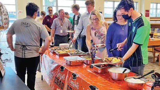 Students and families get some breakfast at Hutto High School in Hutto May 23.