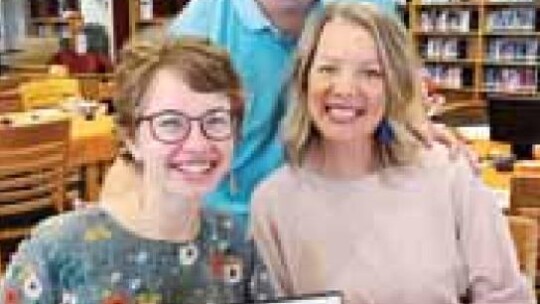 Hannah Laurence is pictured holding her certificate of excellence from Hutto ISD May 23 alongside her parents, Reagan and Meghan Laurence. Facebook / Hutto ISD