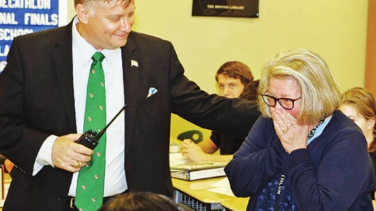 Principal Andrew Maddox (left) helps surprise Taylor High School teacher Vicki Rowe with an award as she bursts into tears during a class in Taylor March 5, 2018. Photo by Tim Crow