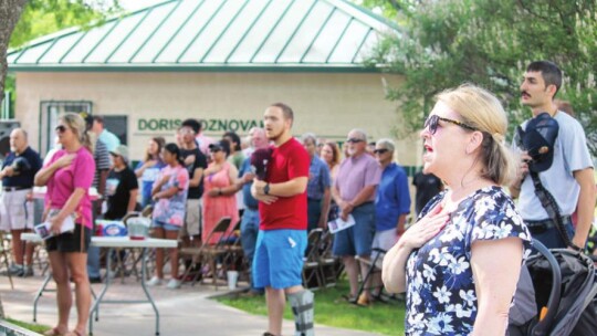 Stacey Osborne (right) and others sing the National Anthem during the Memorial Day Salute at Murphy Park in Taylor May 30.