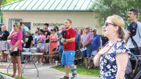 Stacey Osborne (right) and others sing the National Anthem during the Memorial Day Salute at Murphy Park in Taylor May 30.