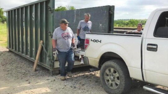 Helping residents put debris in the dumpsters were Buz Garry and Mayor Jack Piper.