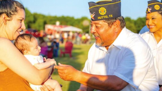 Daniel Castro greets a baby during the Sunset Block Party Bash at Fritz Park in Hutto May 27.