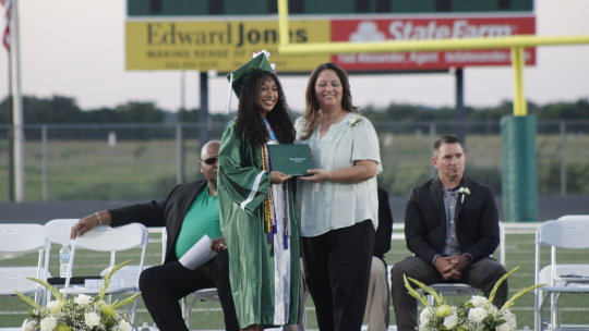 Taylor Independent School District trustee Cheryl Carter (right) hands Samantha McIntyre her diploma during commencement ceremonies May 27 in Taylor. Photo by Matt Hooks