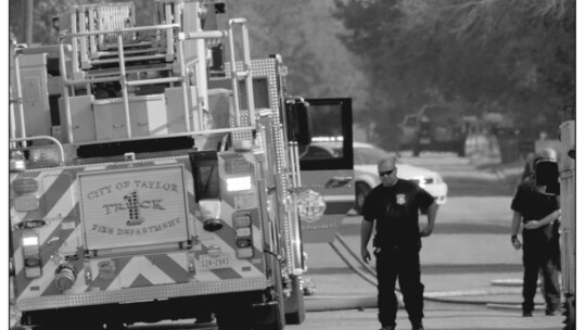 Firefighters walk around fire engines on Debus Drive in Taylor June 16. Photo by Matt Hooks