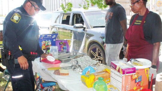 Officer Lauro Luera is served barbecue during Juneteenth celebrations at Fannie Robinson Park in Taylor June 18. Photo by Fernando Castro