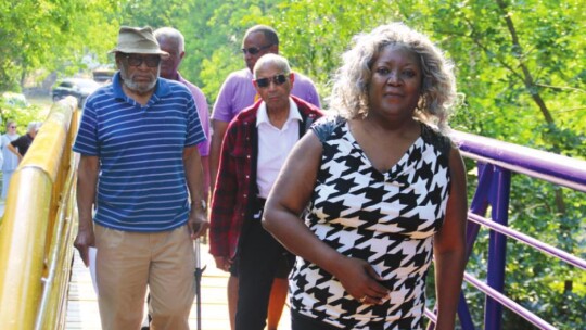 Doris Corely leads other former O.L. Price students Raymond White Jr., Ernest Rector, Rev. James Davis and current Mayor Pro Tem Gerald Anderson across the Dickey bridge.