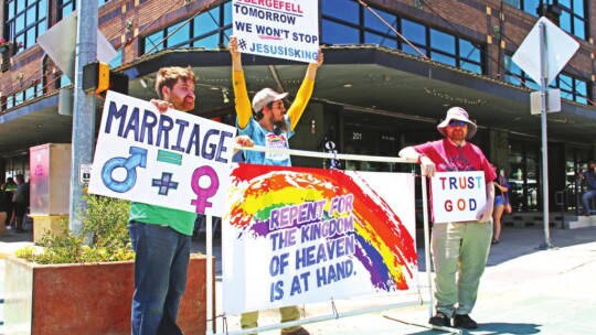 Protesters (from left) Bradley Machita, Spencer Ripple and Chris Connell stand at the corner of Second and Main streets with a different message during the PRIDE festival. Photos by Jason Hennington