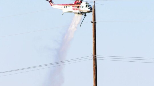 Firefighters used helicopters to pour water onto a brush fire that was hard to reach June 24.