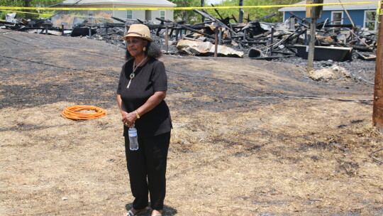 Dickey Museum and Multipurpose Center board president Jennifer Harris stands among the remains of the original home of Dr. James Lee Dickey. photo by Jason Hennington