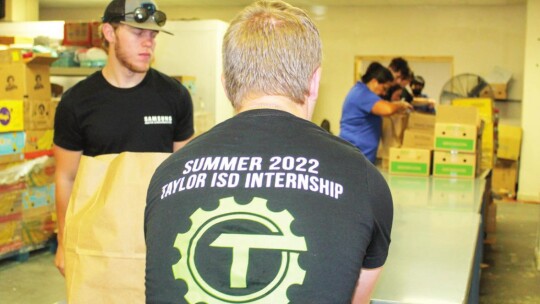 Luke Schneider, Connor Kurtin, Christina Combs and Matt Aplin volunteer at Shepherd’s Heart Food Pantry and Community Ministries in Taylor July 21 as part of an organized volunteer opportunity for Samsung Austin Semiconductor. Photo by Fernando Castro