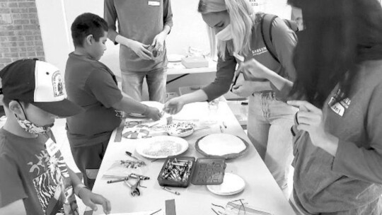 Sadot Martinez Garcia, left, helping Mariela, center, with her project.