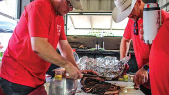 Jason Vrana slices some brisket at the Taylor International Barbecue Cookoff in Taylor Aug. 20. Photos by Fernando Castro