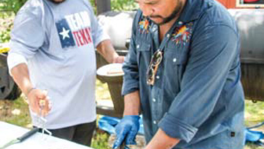 Geraldo and Fernando Reyes slice some brisket at the Taylor International Barbecue Cookoff in Taylor Aug. 20.