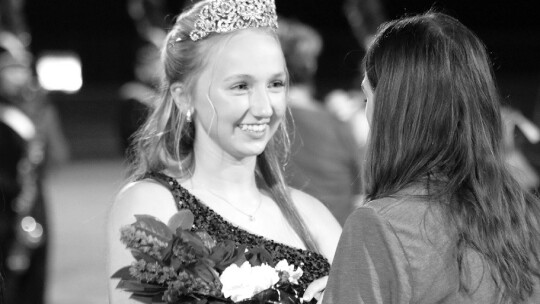 Autree Kelm smiles as she receives her crown and flowers when she is named homecoming queen.