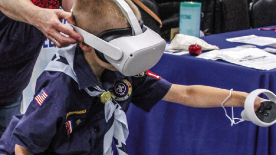 Workforce Solutions Rural Capital Area Facilitator Kelly Langley helps Evan Eschberger, 8, use a virtual reality headset during the Business Expo Sept. 10. Photo by Nicole Lessin