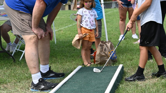 Tim Nemec (left) and other golfers anxiously watch the ball get closer to the hole, hoping for a hole in one at the St. Mary’s Fall Festival.