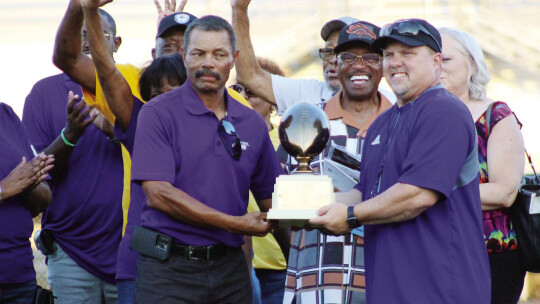 “State championships are hard to come by,” said Brandon Houston (right), Taylor Duck head football coach. Houston and Edward Elder hold the O.L. Price state championship trophy before the homecoming game Friday night. Photo by Catherine McGary