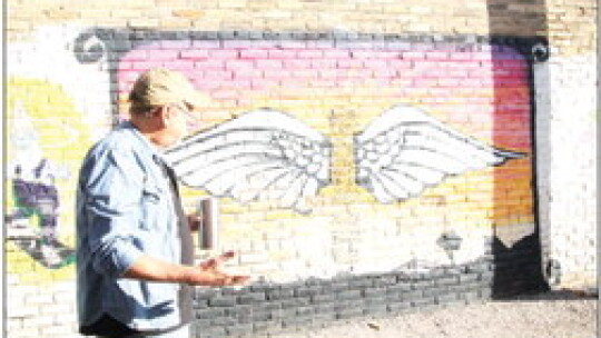 Arts Committee Chair Richard Stone shows the “Wings” mural to public works staff Sept. 30 in Potters Alley. Photo by Nicole Lessin