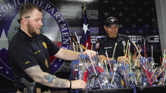 Sergeant Josh Bellenir and officer Randy Wheeler filled hundreds of goody bags for officers to hand out Oct. 4 at neighborhood parties in Hutto. Photos by Edie Zuvanich