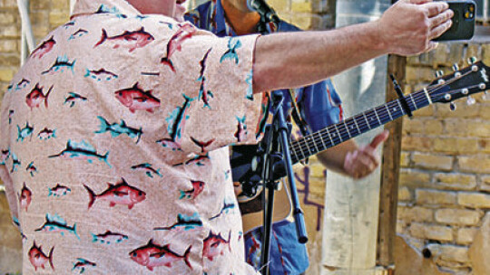 Paul Leal, constable for Williamson County Pct. 4., films a video of musician Garrett Pekar performing Oct. 8 at the Empty Bowl FUNdraiser in Potter’s Alley.