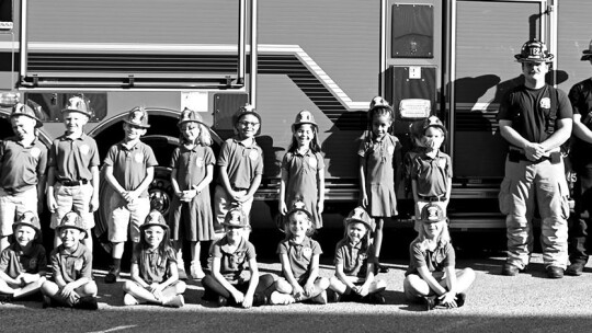 Mrs. Hime’s first grade class at St. Mary’s poses with the firefighters.