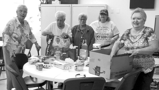 Local bingo and domino players help unpack gifts from the Taylor Area Businesswomen organization.