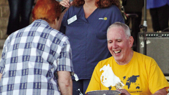 George Qualley, senior pastor at Saint Paul Lutheran Church, smiles after receiving a pie to the face Oct. 20 at Heritage Square Park as organizer and Taylor’s Rotary Club President Tia Rae Stone laughs in the background.