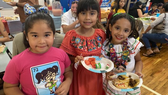 Mariana Arenas Gonzales, Estrella Blas-Vallejo, and Ximena Loredo display some of the dishes at Cultural Night. Photo by Kate Knapek