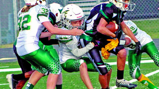 Youth Ducks running back Adrian Proctor break tackles on his way to a touchdown.