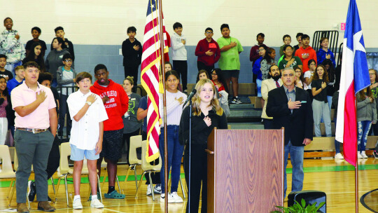 Students, faculty and staff at Taylor Middle School recite the Pledge of Allegiance during the annual Veterans Day tribute. Photo by Tim Crow