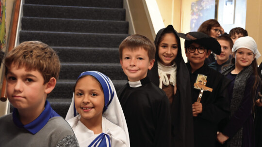 St. Mary’s fourth grade students walk through the halls during the saint parade.