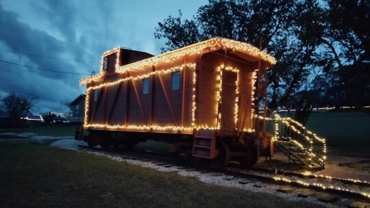 Coupland Civic Organization board member Jonathan Jones decorates the Depot and caboose for Christmas as the centerpiece of Coupland’s Trail of Lights. Photo by Jonathan Jones