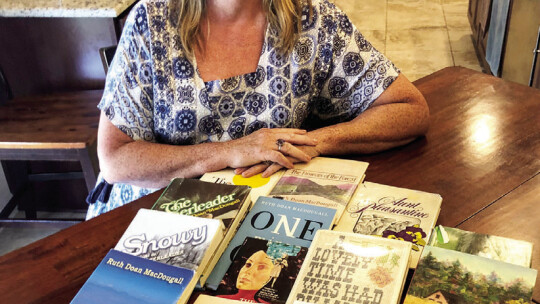 Butler, displays books by her favorite author, Ruth Doan MacDougall.