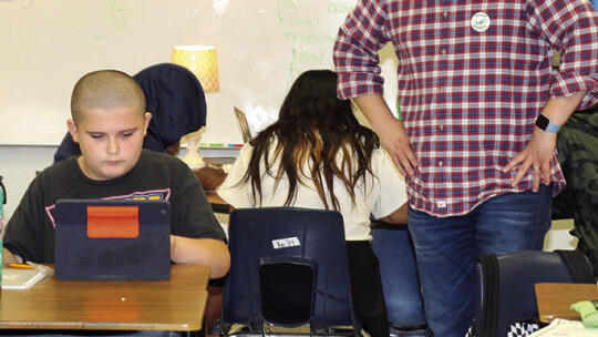 Taylor ISD Ambassador Brady Collier observes a student working during a classroom visit at Main Street Intermediate.