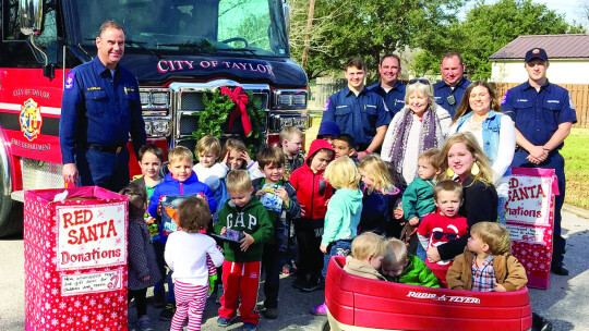 Donors from First United Methodist Church Taylor pose with members of the Taylor Fire Department for their annual Red Santa program. Courtesy photo