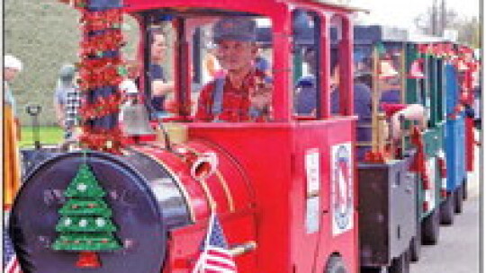 Kids stood eagerly in line to board the Kiddie Train and take a ride around the Downtown Christmas Fair. Larry Piper played conductor for the ride.